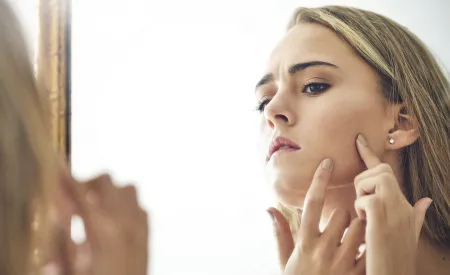 teenager examines her skin